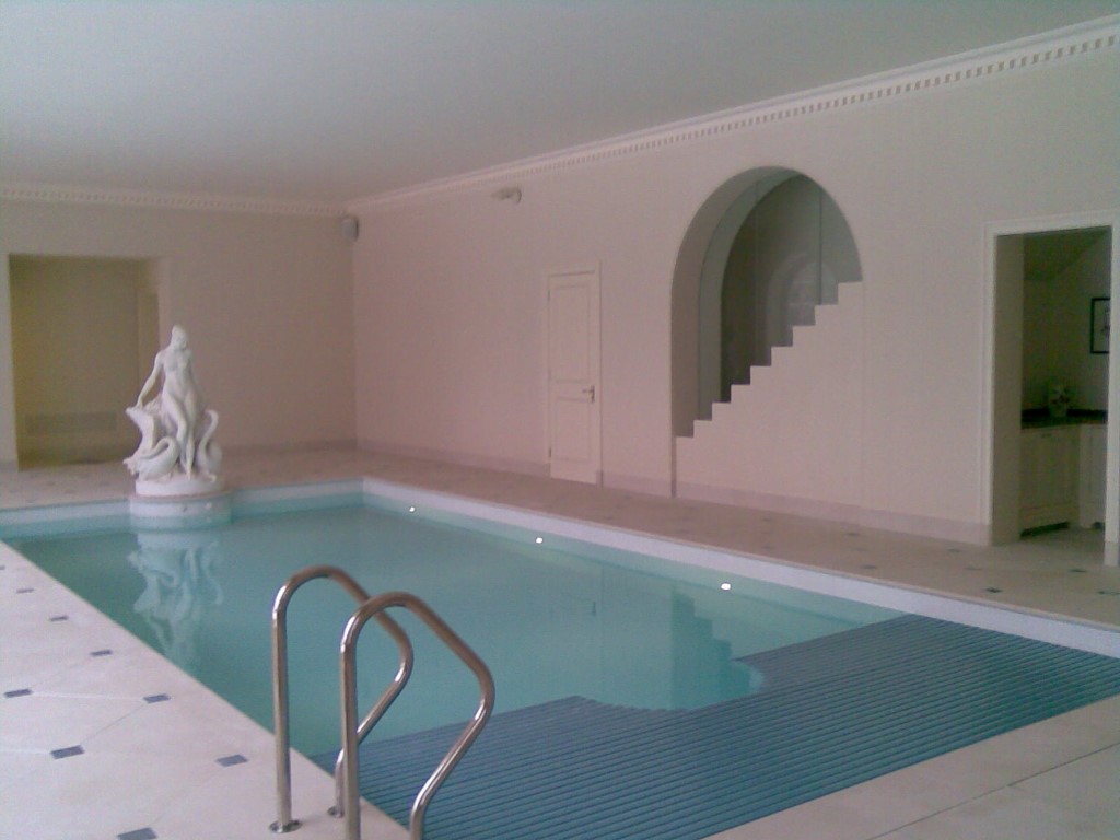 Indoor swimming pool with specialised cover covering half of the pool 2